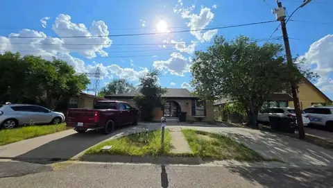 Street view of the home with a strip of patchy grass and dirt before work began