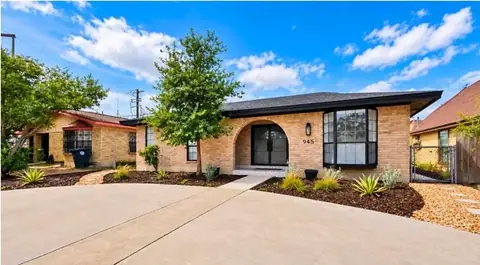 The finished front yard seen from the side, with planted beds and gravel beside the driveway