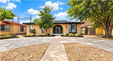 Finished front yard with a straight walkway between two gravel beds leading to an arched front door